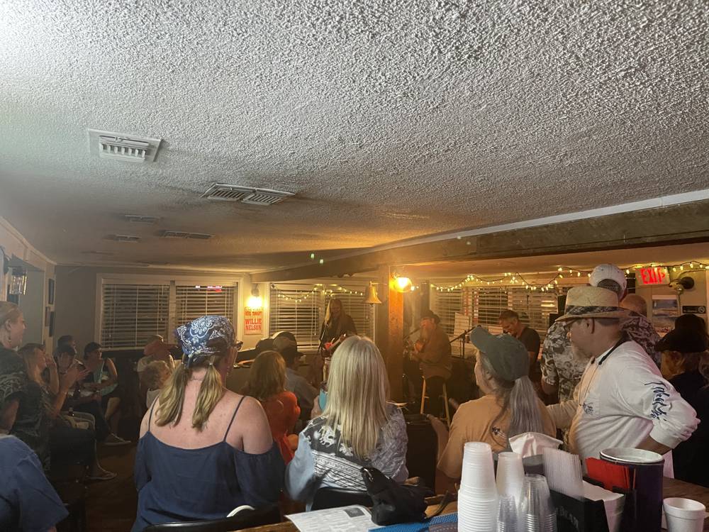 Packed dining room enjoying live music inside The Point Restaurant Perdido